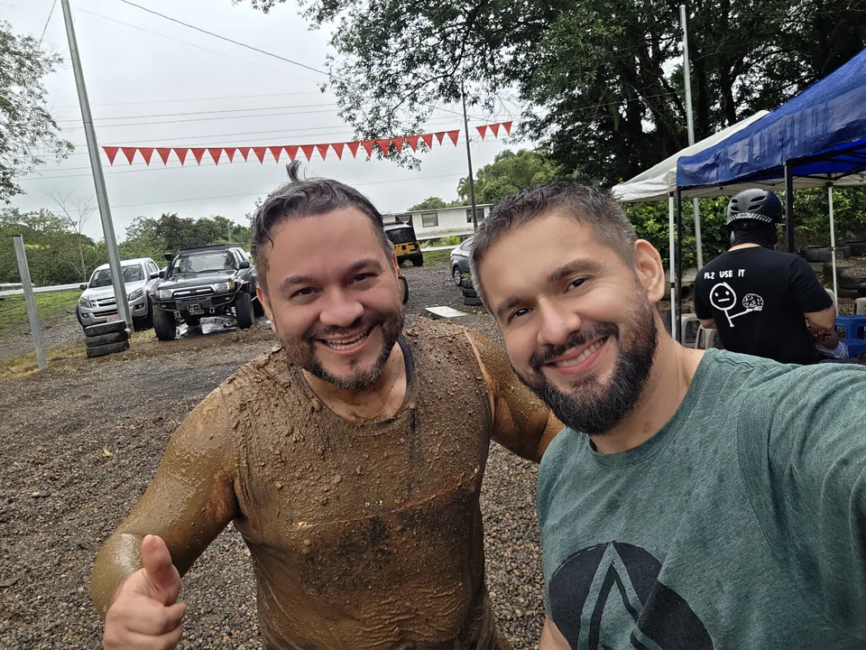 Dos amigos cubiertos de lodo sonríen al terminar su recorrido en go karts en Sarapiquí Race Park